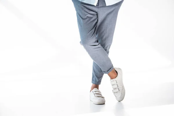 Обрезанный снимок человека в стильных брюках и белых туфлях, стоящих на белом — стоковое фото