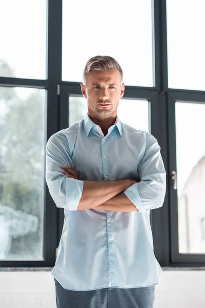 Serious adult man in shirt looking at camera with crossed arms — Stock Photo