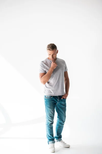 Bonito adulto homem no branco cinza t-shirt de pé no branco — Fotografia de Stock