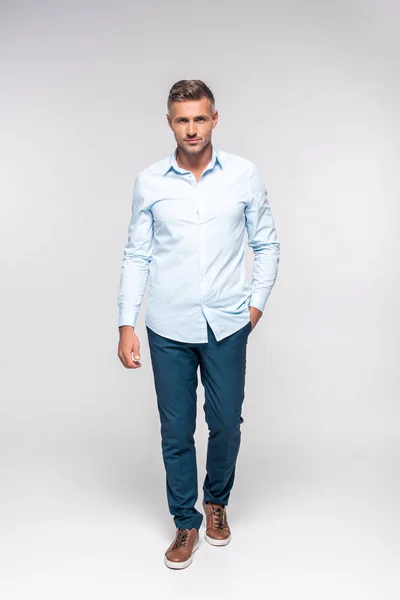 Schöner erwachsener Mann in stylischer Kleidung mit Blick auf Kamera auf weiß — Stockfoto