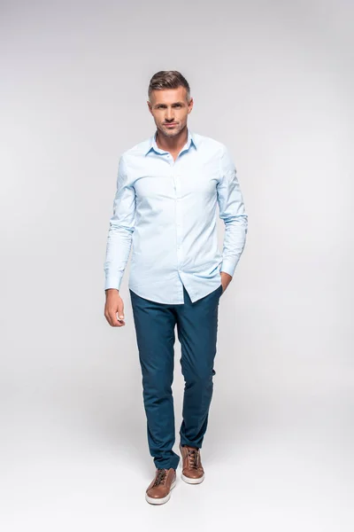 Hombre adulto guapo en ropa elegante mirando la cámara en blanco - foto de stock