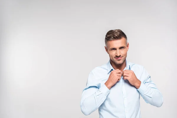 Handsome adult man buttoning shirt isolated on white — Stock Photo