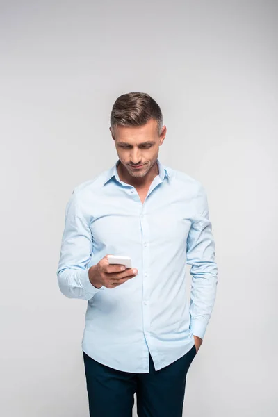 Homem adulto bonito usando smartphone isolado no branco — Fotografia de Stock