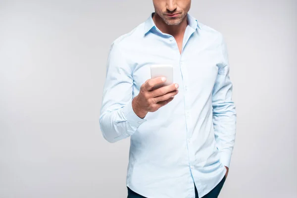 Обрезанный снимок красивого взрослого мужчины с помощью смартфона, изолированного на белом — стоковое фото