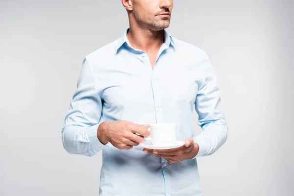 Recortado disparo de hombre adulto guapo sosteniendo taza de café aislado en blanco - foto de stock