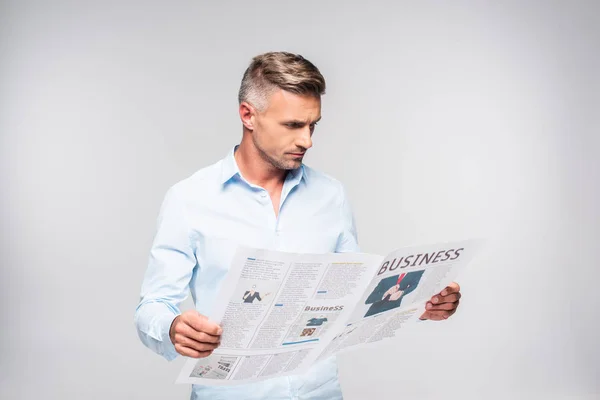 Guapo adulto hombre de negocios leyendo periódico de negocios aislado en blanco - foto de stock