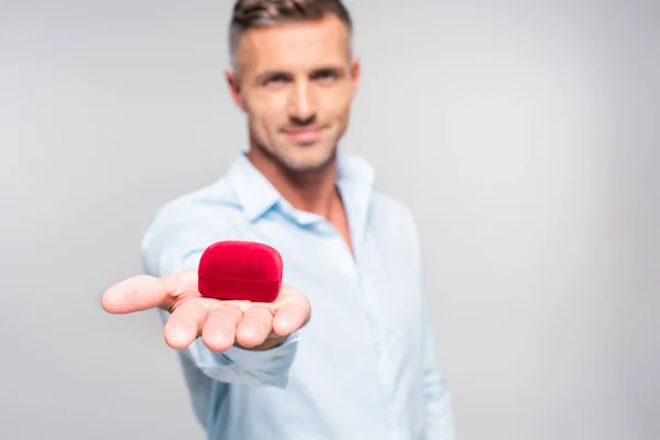 Nahaufnahme eines gut aussehenden erwachsenen Mannes mit roter Schachtel für einen Vorschlag isoliert auf weiß — Stockfoto