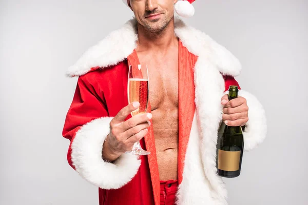 Cropped shot of sexy santa holding glass of champagne and bottle isolated on grey — Stock Photo