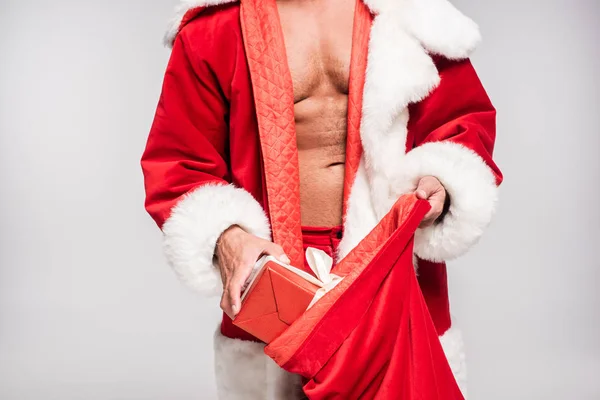 Plan recadré de l'homme sexy en costume de Père Noël tenant sac avec des cadeaux isolés sur gris — Photo de stock