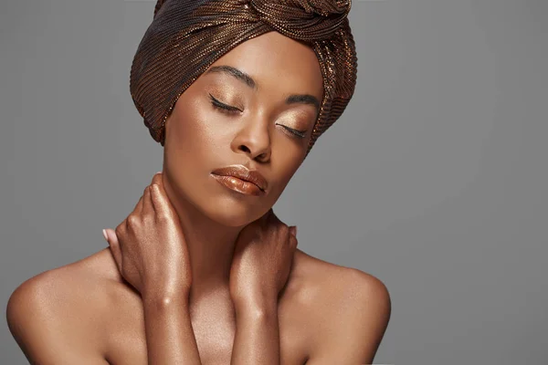 Retrato de bela mulher afro-americana com envoltório na cabeça e ombros nus isolados em cinza — Fotografia de Stock