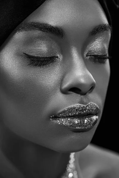 Black and white photo of stylish african american woman with eyes closed isolated on black — Stock Photo