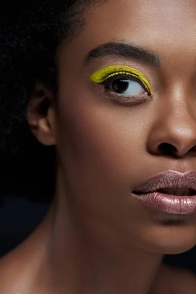 Partial view of african american model with bright neon eye shadow isolated on black — Stock Photo