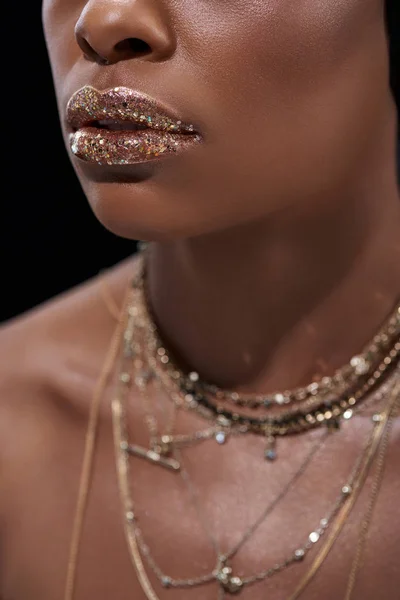 Обрізаний знімок афроамериканської жінки з блискучим блиском для губ ізольовано на чорному — стокове фото