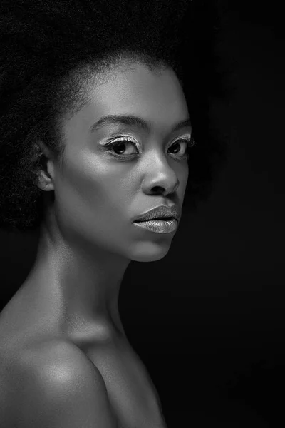 Black and white photo of thoughtful african american woman isolated on black — Stock Photo