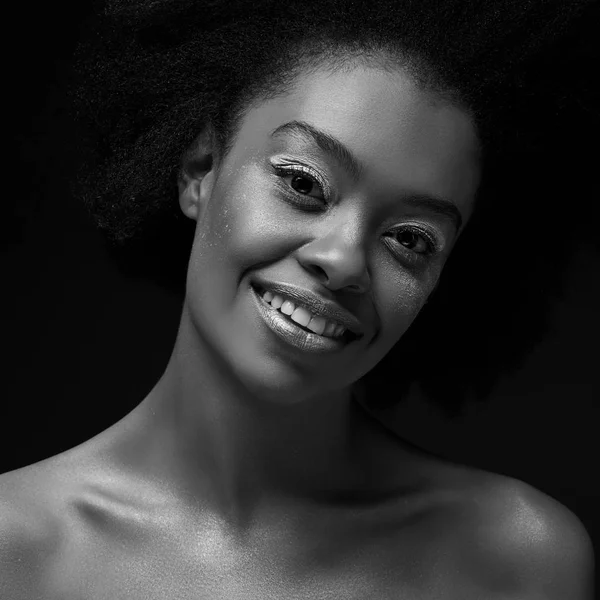 Schwarz-Weiß-Foto der attraktiven afrikanisch-amerikanischen Frau, die in die Kamera schaut, isoliert auf schwarz — Stockfoto