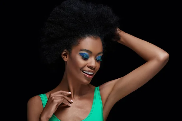 Portrait of attractive african american model with bright blue eyes shadows isolated on black — Stock Photo