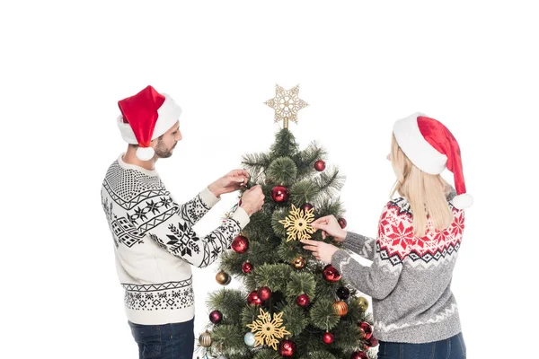 Vista trasera de la novia y el novio en suéteres decorando árbol de Navidad juntos aislados en blanco - foto de stock