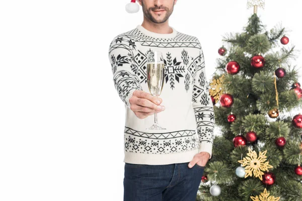 Tiro cortado do homem em suéter com copo de champanhe de pé perto da árvore de natal isolado em branco — Fotografia de Stock