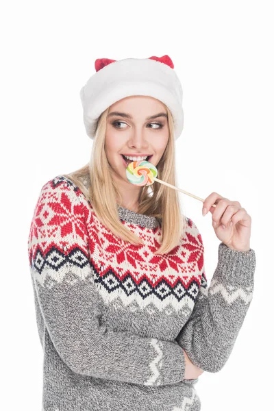 Porträt einer schönen Frau in Pullover und Weihnachtsmannmütze mit Lutscher auf weißem Hintergrund — Stockfoto