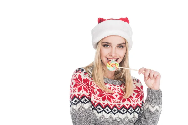 Portrait of woman in sweater and santa claus hat with lollipop isolated on white — Stock Photo