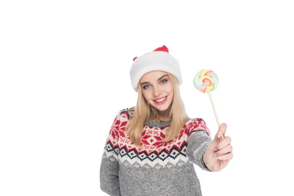 Retrato de mujer joven en suéter y sombrero de santa claus con piruleta aislada en blanco - foto de stock