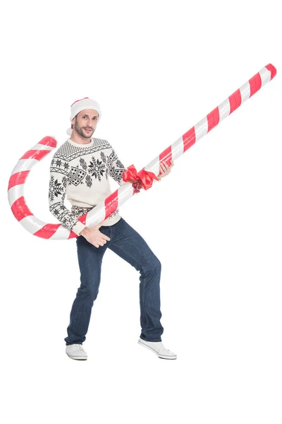 Молодий чоловік в светрі і капелюсі Санта Клауса з іграшковою цукеркою ізольовані на білому — стокове фото