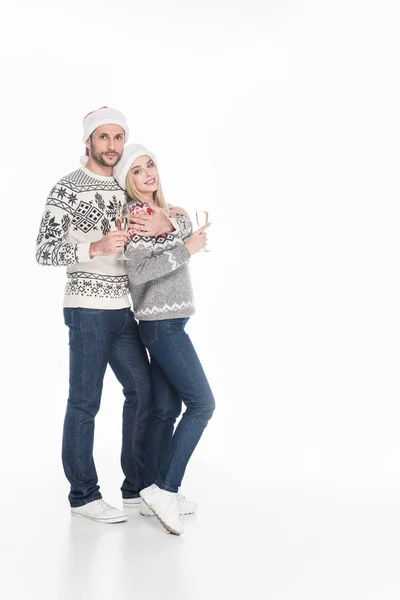 Young couple in sweaters with glasses of champagne isolated on white — Stock Photo