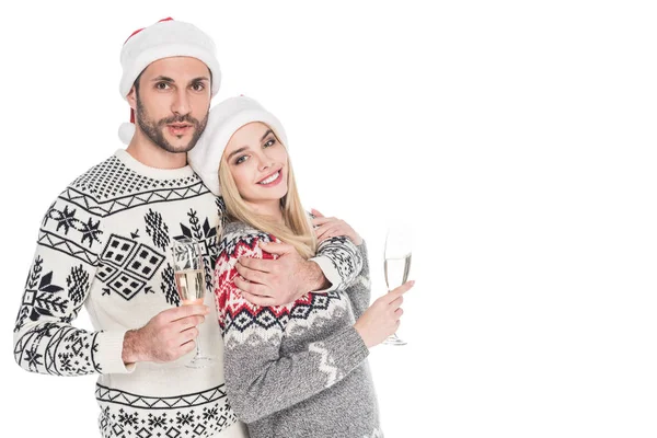 Portrait of smiling couple in santa claus hats with glasses of champagne isolated on white — Stock Photo