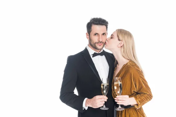 Retrato de mujer elegante besar novio con copa de champán aislado en blanco - foto de stock