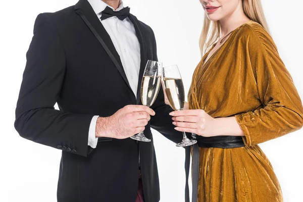 Vue partielle du couple à la mode cliquetis verres de champagne isolé sur blanc — Photo de stock