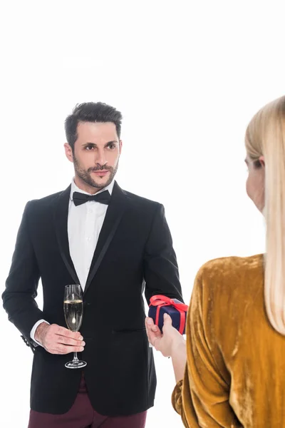 Vue partielle de l'homme avec verre de champagne présentant cadeau à petite amie isolée sur blanc — Photo de stock