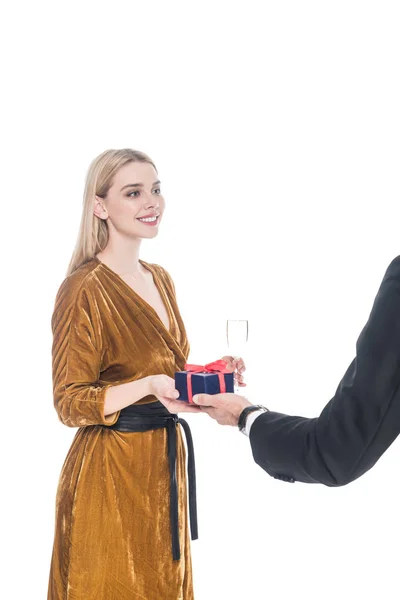 Teilansicht des Mannes, der seiner schönen Freundin verpacktes Geschenk mit einem Glas Champagner auf Weiß präsentiert — Stockfoto