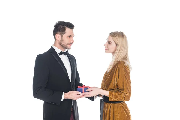 Junger Mann präsentiert verpacktes Geschenk an schöne Freundin isoliert auf weiß — Stockfoto