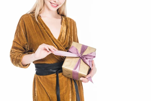 Partial view of smiling woman with wrapped gift in hands isolated on white — Stock Photo