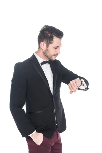 Joven en traje de moda comprobar el tiempo aislado en blanco - foto de stock