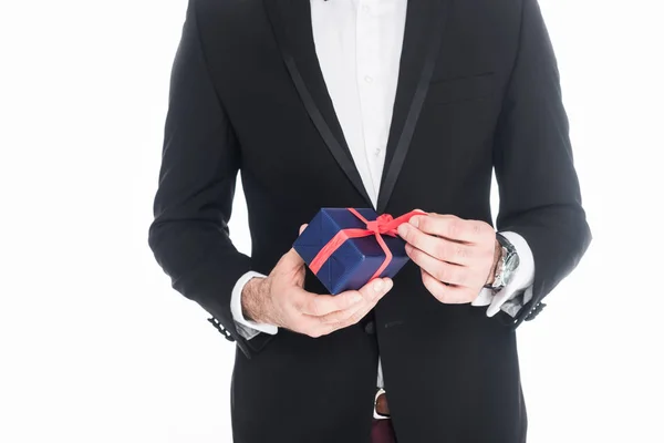 Cropped shot of man in stylish suit holding wrapped present isolated on white — Stock Photo