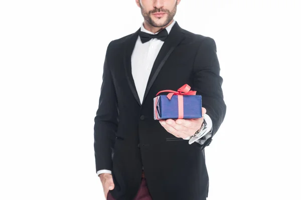 Cropped shot of man in stylish suit holding wrapped present isolated on white — Stock Photo