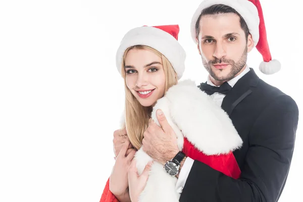 Young man putting santa claus costume on girlfriend isolated on white — Stock Photo