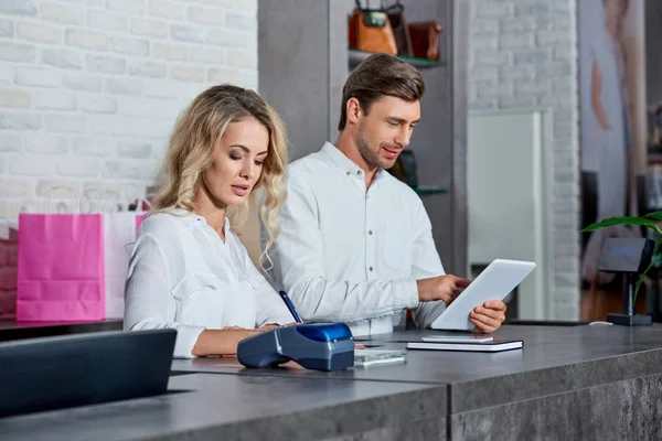 Young man and woman working together in shop — Stock Photo