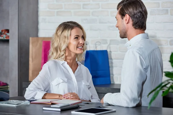 Happy young coworkers smiling each other while working in store — Stock Photo