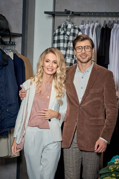 Beautiful stylish couple smiling at camera in store — Stock Photo