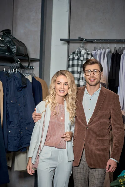Beautiful stylish couple smiling at camera in boutique — Stock Photo