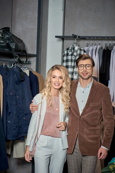 Beau couple élégant souriant à la caméra en boutique — Photo de stock