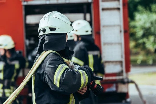 Vue partielle de la brigade des pompiers et camion de pompiers sur la rue — Photo de stock