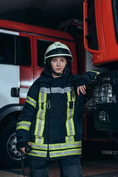Portrait of female firefighter in protective uniform with portable radio set at fire department — Stock Photo