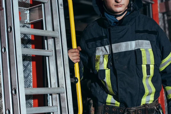 Schuss auf Feuerwehrmann in Schutzuniform am Feuerwehrhaus — Stockfoto