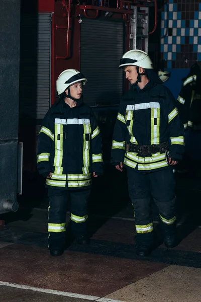 Firefighters in protective uniform and helmets at fire department — Stock Photo