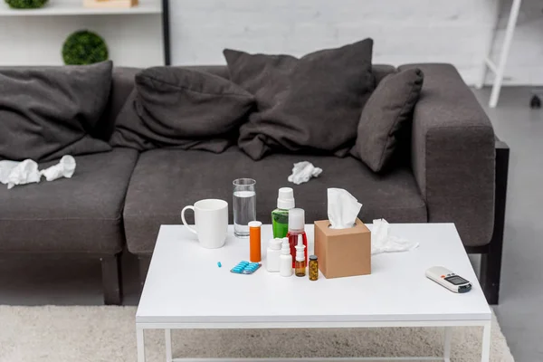 Table with various medicines and couch at living room — Stock Photo