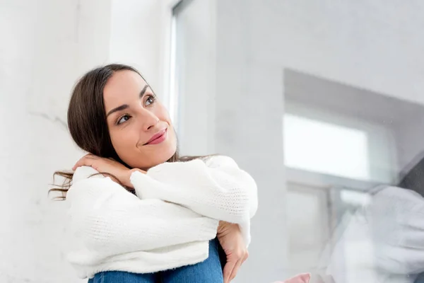 Vue du bas de sourire réfléchi jeune femme levant les yeux — Photo de stock