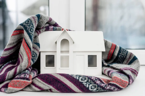 Close-up shot of miniature house model with plaid on windowsill — Stock Photo